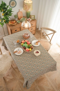 Close-up of vintage floral jacquard tablecloth with rustic botanical pattern on beige fabric
