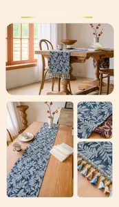 Detail of blue botanical jacquard table runner featuring woven leaf patterns and tassels