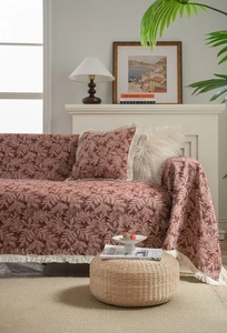 Detail view of retro terracotta leaf jacquard sofa cover with elegant cream fringe tassels