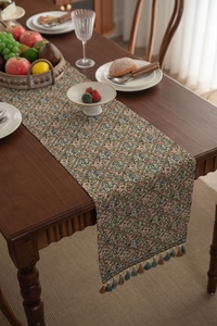 Detail of French vintage table runner with floral jacquard pattern and tassel fringe