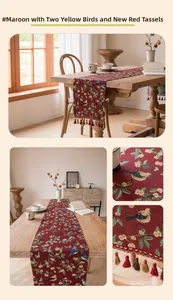 Detail of burgundy table runner with jacquard bird and flower patterns and tassels