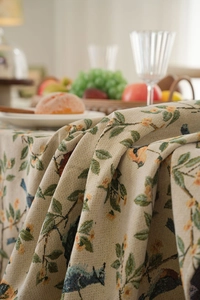 Close-up of thick jacquard tablecloth fabric featuring elegant bird and floral patterns