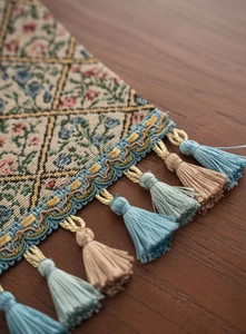 Detailed close-up of Jacquard table runner featuring floral patterns and tassels