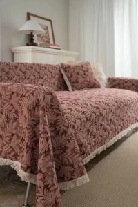 Detail of retro floral jacquard sofa throw blanket with elegant cream fringe edges