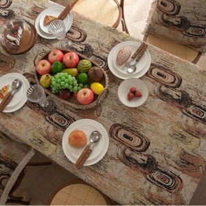 Thick jacquard tablecloth with abstract rings and earthy tones featuring fringe tassels