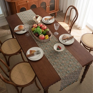 Nordic floral jacquard table runner with tassel fringe on dark wood dining table
