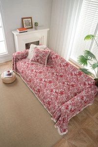 Detailed red jacquard sofa cover with floral patterns and delicate white fringe tassels