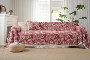 Detail of red Toile de Jouy sofa cover with dense fringe edges and animal motifs