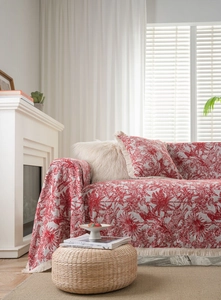 Detail view of red French Toile de Jouy floral pattern on a thick sofa cover with tassels