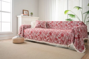 Detail of red vintage Toile de Jouy jacquard sofa cover with white fringe edges