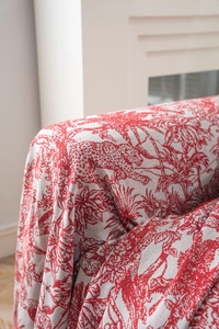 Close-up of red Toile de Jouy jacquard fabric with leopard and tropical palm motifs