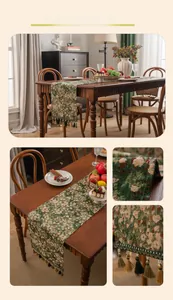 Detail of floral jacquard table runner with green grass pattern and tassel trim accents