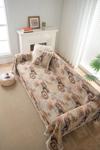 Gros plan sur le motif géométrique et les franges blanches du jeté de canapé épais avec coussin