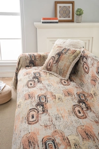 Détail du jeté de canapé en tissage jacquard avec motifs géométriques et bords à pompons