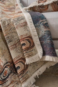 Détail de la couverture jacquard avec franges et motifs de cercles abstraits orange