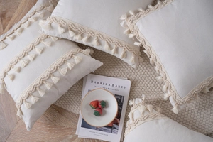 Close-up of cream boho pillow cover with wave woven tape and decorative fringe tassels