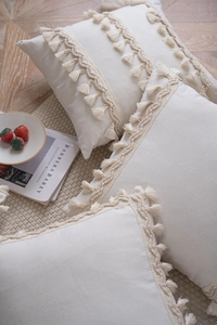 Detailed view of bohemian linen cushion cover with woven wavy lace and tassel fringe edges