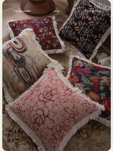 Detail of jacquard sofa cushion covers with floral patterns and fine fringe trim edges
