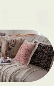 Detailed texture of jacquard throw pillows with elegant fringe trim on a cozy sofa