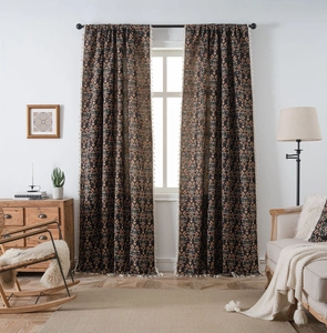 Close-up of black floral blackout curtains with pink small flowers and white woven tassels