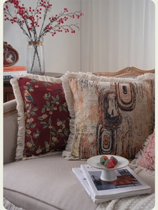Detail of bohemian jacquard pillows with bird embroidery and fringe on a French sofa