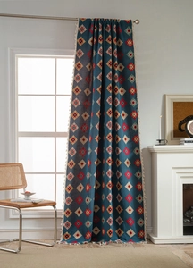 Detail of blue geometric jacquard curtain fabric with white fringe tassel edges