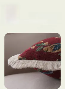 Detailed view of jacquard floral cushion with thick white fringe and woven texture