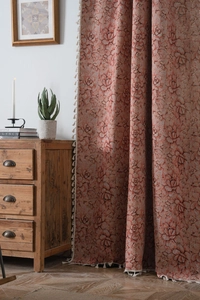 Detail of vintage reddish-brown floral jacquard curtain with elegant white tassel fringe