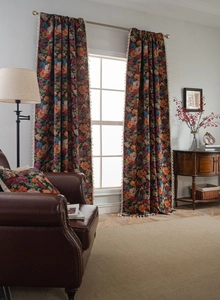 Detail of floral jacquard curtains with elegant white tassel trim and thick fabric