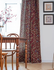 Detail of red floral and bird jacquard curtain with fine cream white tassels on edges