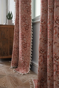 Detail of heavy jacquard floral fabric curtains with decorative cotton tassels and fringe