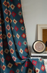 Detailed view of bohemian blue geometric jacquard knit blanket with beige tassels