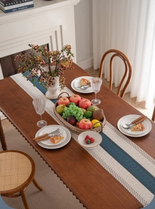 Detailed close-up of blue and white striped table runner with intricate hollow lace edges
