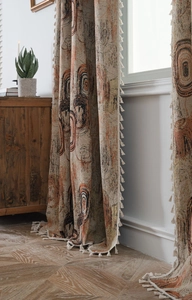 Detail of jacquard curtains with abstract ring patterns and decorative tassel edges