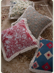 Macro shot of jacquard throw pillow covers with vintage floral patterns and fringe edges