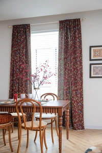 Detail showing vintage red floral bird pattern curtain with cream tassel trim on edge