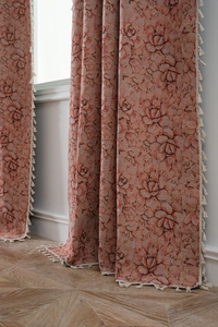 Detailed view of pink floral jacquard fabric with elegant beige tassel fringe border