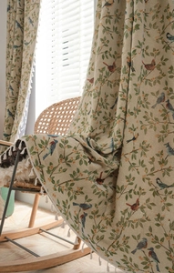 Detail of floral jacquard curtain fabric with bird patterns and white fringe tassels