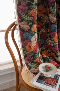 Detail of floral jacquard woven tapestry with fringe edge on a vintage wooden chair