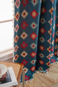 Detailed view of blue geometric jacquard fabric with bohemian patterns and white tassels