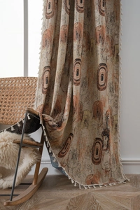 Detail of bohemian jacquard curtain with concentric circle patterns and fringe edges