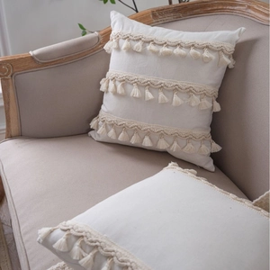 Bohemian cream throw pillow cover with triple layer tassels on a cozy vintage sofa