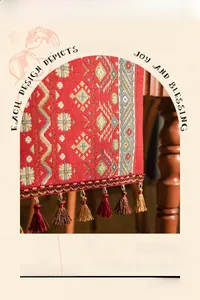 Close-up of red vintage table runner with intricate diamond jacquard and golden tassels