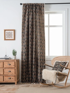 Close-up of black floral jacquard curtain fabric with decorative white fringe details