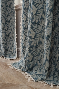 Detailed view of blue leaf jacquard curtains with elegant white tassel fringe edges