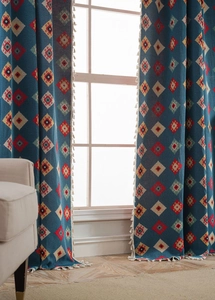 Detailed blue bohemian curtain with geometric diamond patterns and white tassel trim