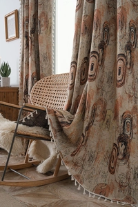 Detailed view of beige curtains with abstract jacquard pattern and decorative white fringe