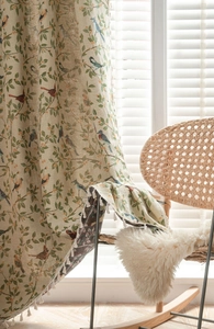 Close-up of jacquard floral bird pattern and fringe edge detail on woven curtain fabric