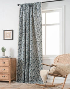 Detail view of blue tropical leaf jacquard curtains with white decorative tassel trim