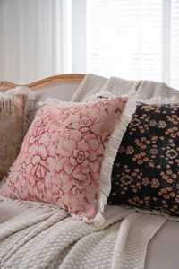Close-up of jacquard throw pillows with elegant floral patterns and fringe tassels